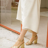 sandalias doradas con tacón alto